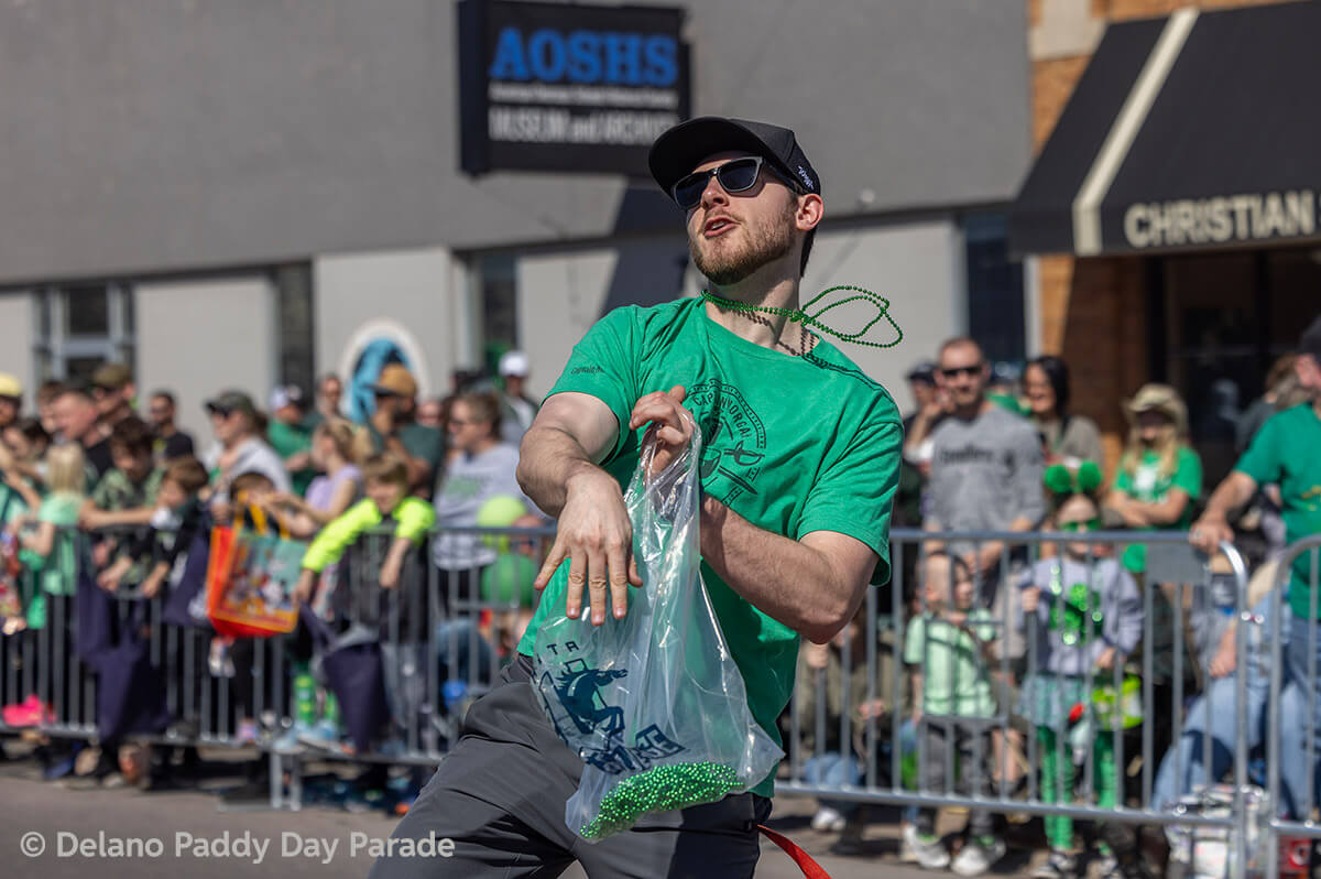 A man tossed beaded necklaces to the crowd.