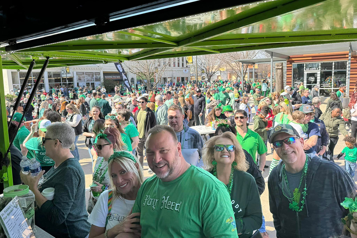 Parade-goers enjoy the after party, smiling at the camera.