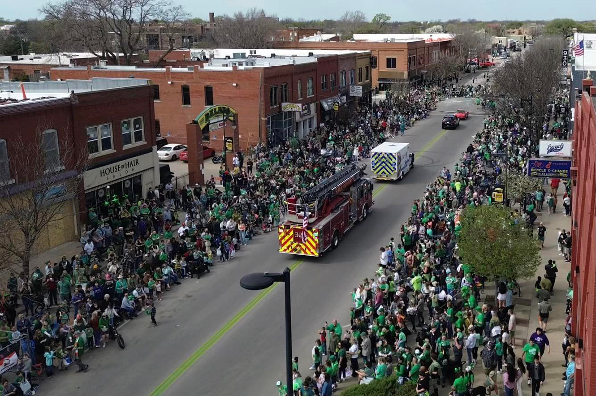 Aerial view of the Delano Paddy Day Parade featuring Wichita Fire Department and Ambulance vehicles.
